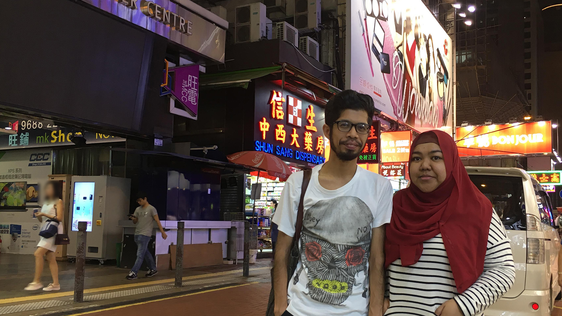 Husband and Wife standing in the middle of a road in Hong Kong